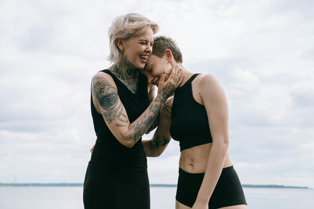 A young lesbian couple laughing together outside